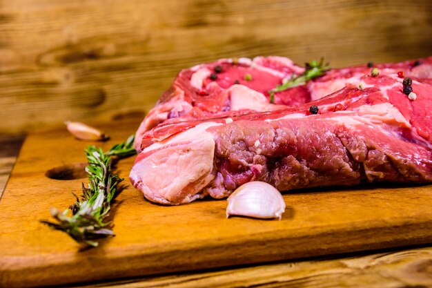 Raw ribeye steak spices rosemary and garlic on cutting board