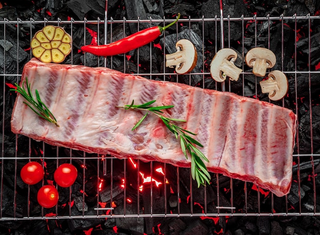 Raw ribs on the grill burning coals on the grill