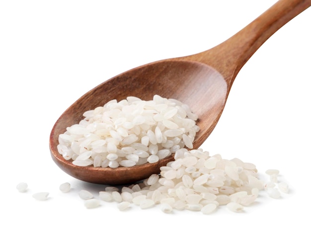 Raw rice in a wooden spoon close-up on a white background. Isolated