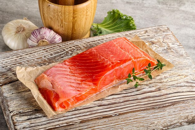 Raw salmon fillet over board