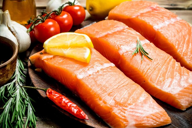 Raw salmon fish filet with lemon tomatoes and herbs