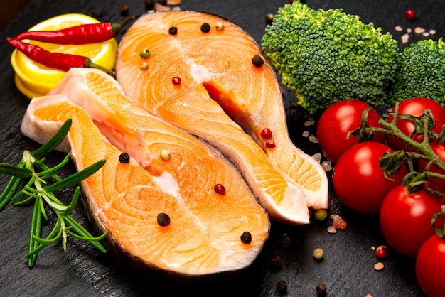 Raw salmon steak on wooden board close up