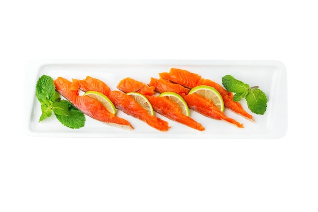 Raw salted salmon pieces with lemon in a white snack plate Appetizing popular dish Top view Closeup Isolated on white background