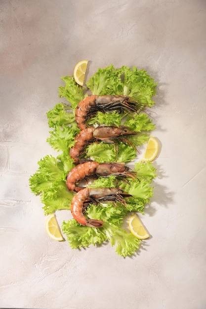 Raw shrimp are located on the leaves of green salad