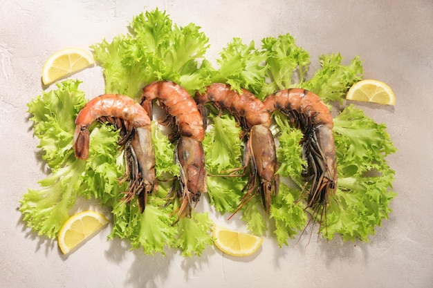 Raw shrimp are located on the leaves of green salad