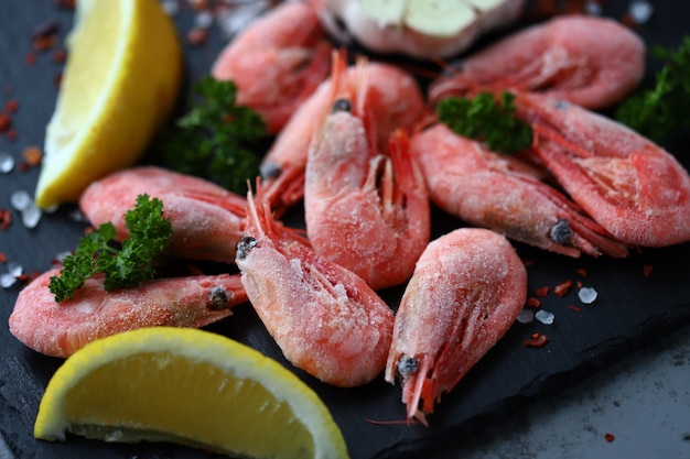 Raw shrimps with spices on a stone board