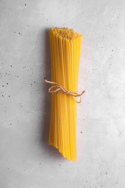 Raw spaghetti. Dry italian pasta prepared from durum wheat, gray background, top view