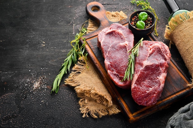 Raw Steak Ribeye On a black stone table Top view Free space for your text