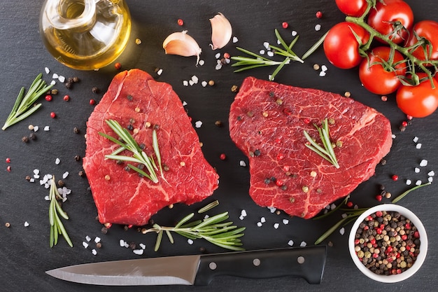 Raw steak with spices and ingredients for cooking. Top view