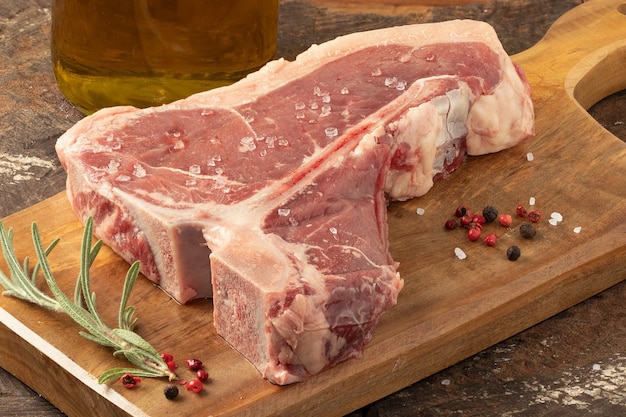 Raw T-bone steak on cutting board