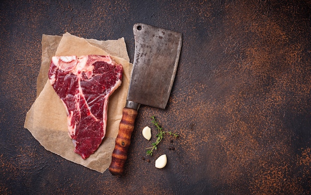 Raw T-bone steak with butchers knife