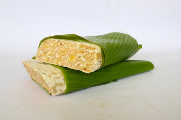 Raw tempeh or tempe tempeh slices in white background raw soybean seeds Tempe is a traditional Indonesian food made from fermented soybeans