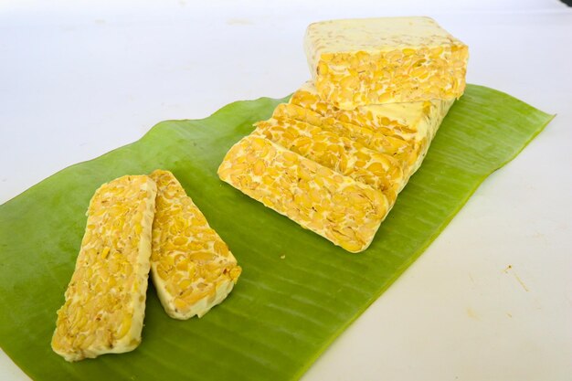 Raw tempeh or tempe tempeh slices in white background raw soybean seeds Tempe is a traditional Indonesian food made from fermented soybeans