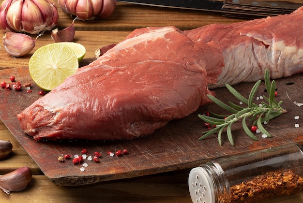 Raw tenderloin and seasonings on cutting board