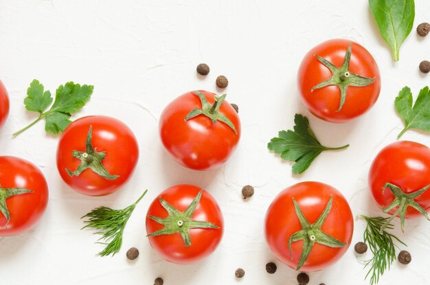 Raw tomatoes herbs and black pepper on a light concrete background Top view with copy space Image