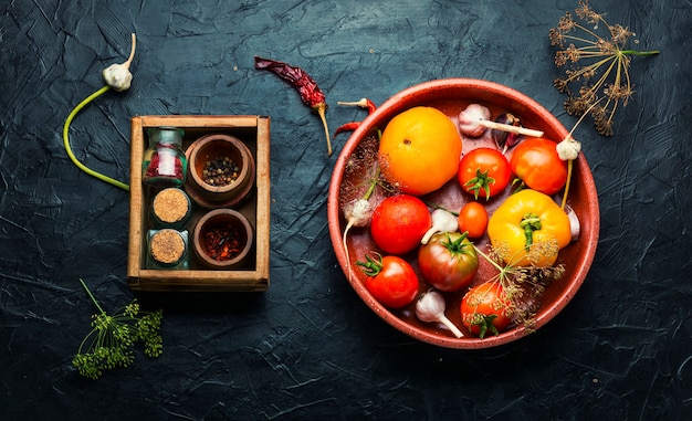 Raw tomatoes and ingredients for cooking pickled tomato