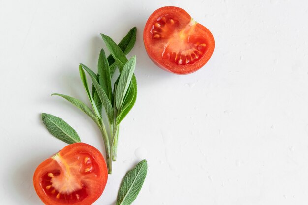 raw tomatoes and wild herbs on white background