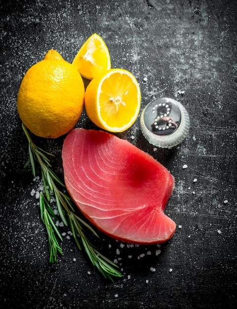 Raw tuna with sliced lemon a sprig of rosemary and salt