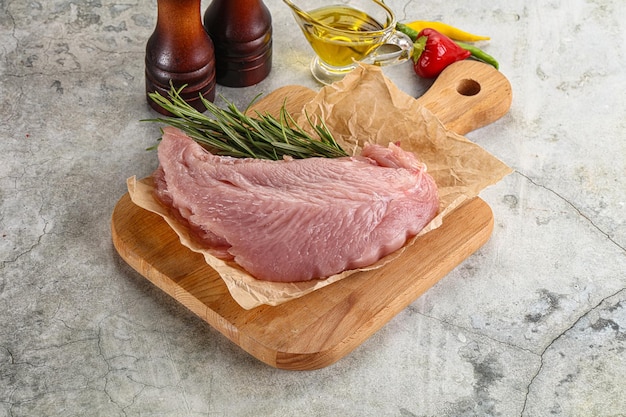 Raw turkey breat fillet for cooking served rosemary