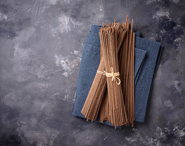 Raw uncooked Japanese soba noodles on grey bacground