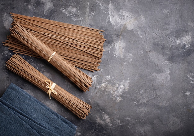 Raw uncooked Japanese soba noodles on grey bacground