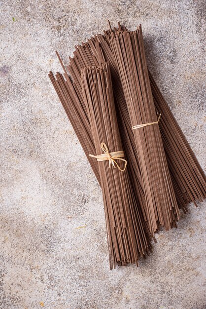 Raw uncooked Japanese soba noodles on light bacground