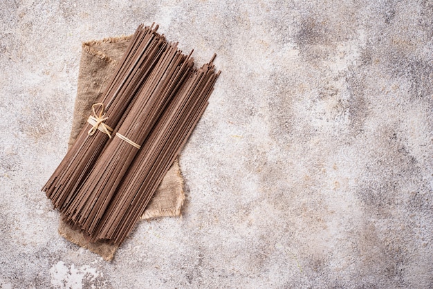 Raw uncooked Japanese soba noodles on light bacground