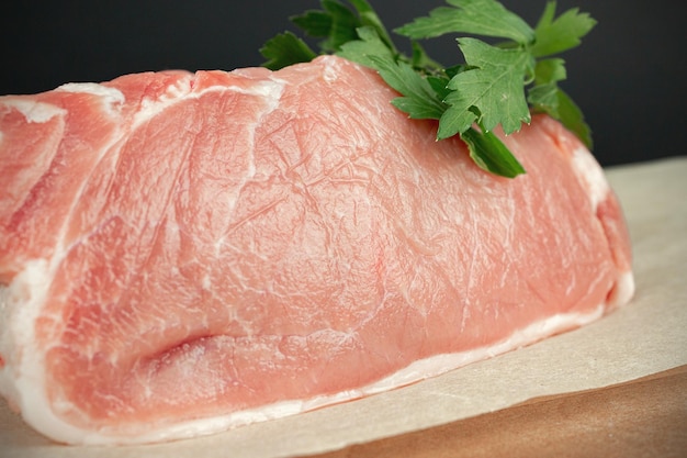 Raw veal meat fillet for grilling with seasoning and utensils on light rustic board