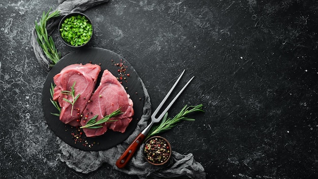 Raw veal meat Two raw steaks with spices Top view Free space for your text