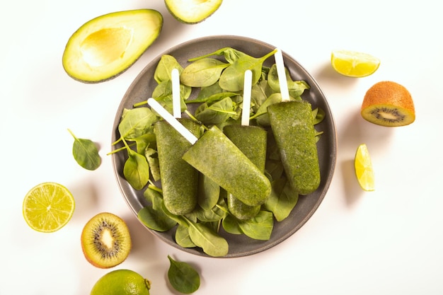 Raw vegan dairy and gluten free ice cream popsicles Delicious dessert made of kiwi avocado and spinach Top view