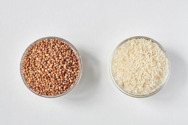 Raw white rice and buckwheat groats in a transparent glass plate