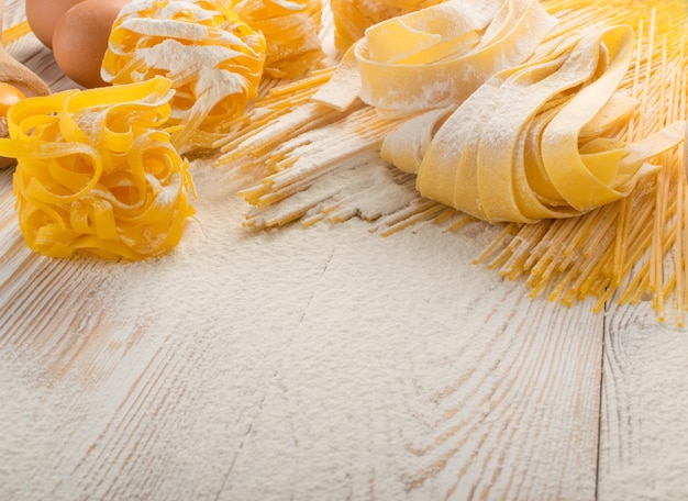 Raw yellow italian pasta pappardelle, fettuccine or tagliatelle