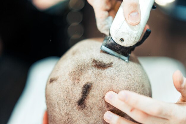 Razor of trimmer is working on male head