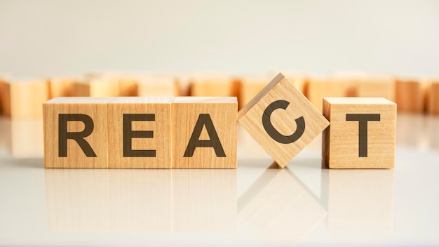 React  word of wooden blocks with letters on a gray background reflection of the caption on the mirrored surface of the table selective focus