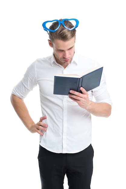 Reading poetry. Man handsome young searching nice poetry. Man busy face in heart shaped eyeglasses reading book. Guy found poetry in book isolated white background. Reading book concentrated.