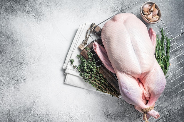 Photo ready for cooking whole duck with thyme and rosemary gray background top view copy space