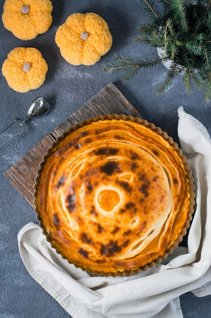 Ready-to-eat fresh sweet layered pumpkin pie in the form on the table. Thanksgiving treat. Top and vertical view