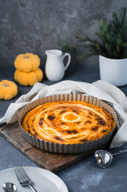 Ready-to-eat fresh sweet layered pumpkin pie in the form on the table. Thanksgiving treat. Vertical view