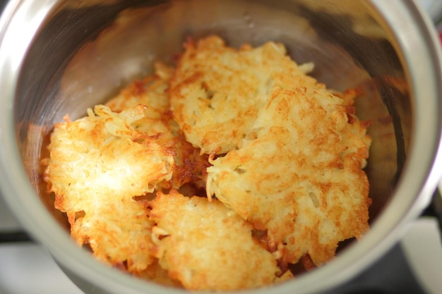 Ready homemade potato pancakes in a pot in a home kitchen Vegetarian food concept Closeup