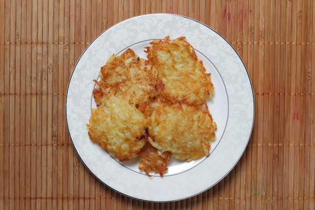 Ready homemade potato pancakes on a white plate on a wooden background Closeup View from above