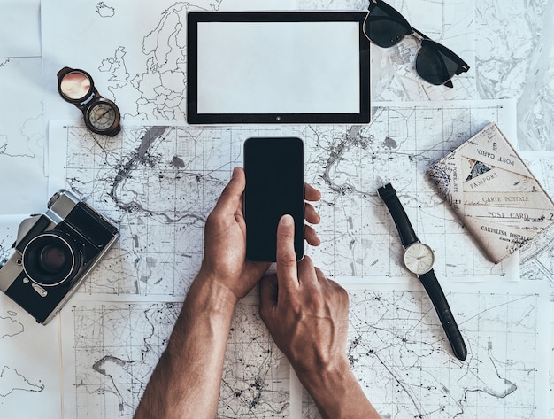 Photo ready to see the world. close up top view of man using smart phone with sunglasses, photo camera