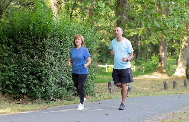 Real Adult Latino Couple Playing Sports and Running in a Green Park to Lose Weight Before Summer