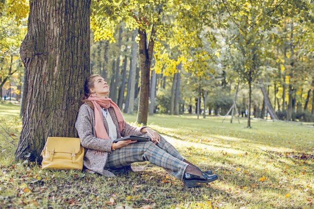 Real businesswoman with tablet laptop at work outdoors in park