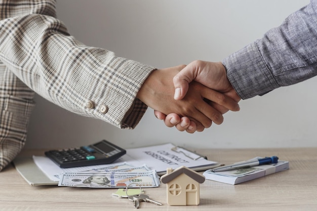 Real estate agent and customer handshake dealing to buy house, insurance or loan real estate.