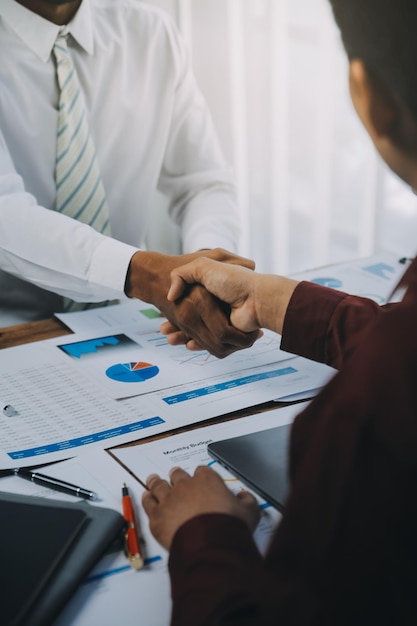 Real estate agent and customers shaking hands together celebrating finished contract after about home insurance and investment loan handshake and successful deal