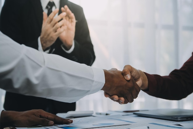 Real estate agent and customers shaking hands together celebrating finished contract after about home insurance and investment loan handshake and successful deal