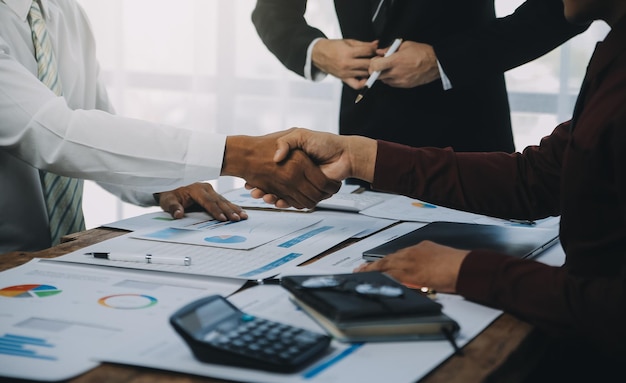 Real estate agent and customers shaking hands together celebrating finished contract after about home insurance and investment loan handshake and successful deal