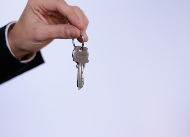 Real estate agent hand with keys on white background.