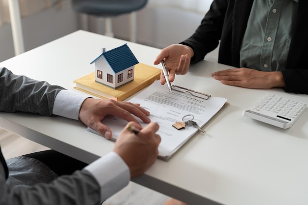 Real estate agent holding house key to his client after signing contractconcept for real estate moving home or renting property