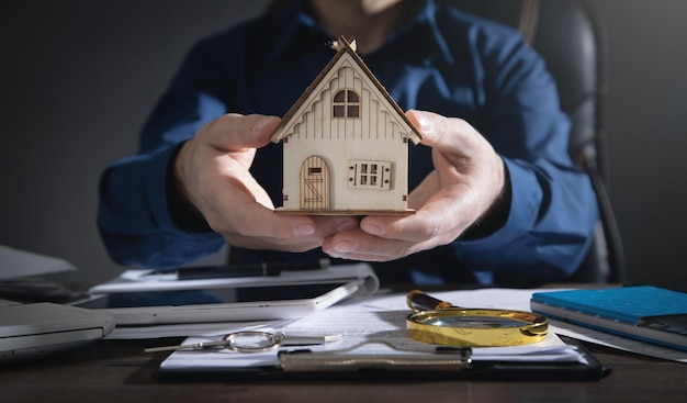 Real estate agent holding house model.